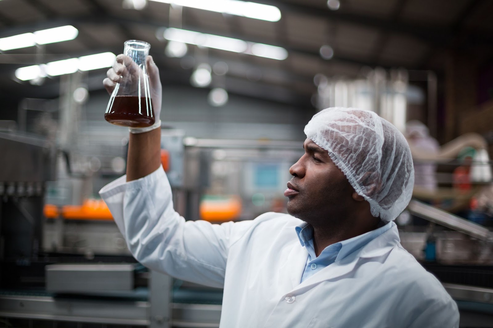 African Cassava's Potential being exemplified with a lab scientist holding ethanol gotten from African Cassava

